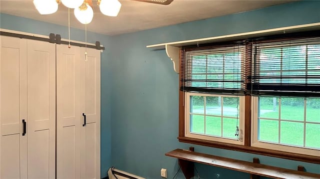 1441 S Maple St, Ottawa, KS 66067 - unfurnished bedroom featuring baseboard heating, a ceiling fan, and a closet