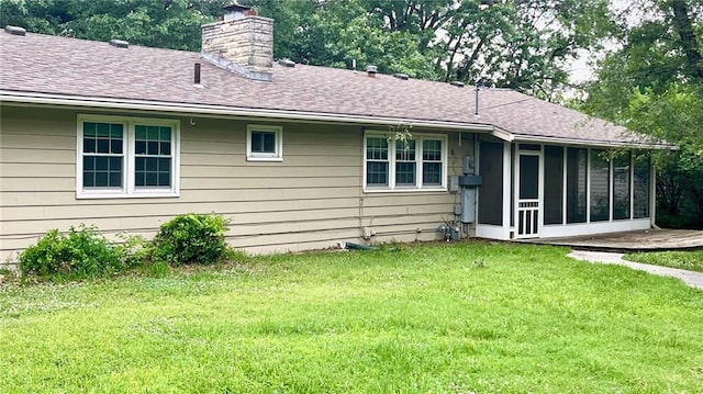 1441 S Maple St, Ottawa, KS 66067 - back of house with a chimney, a sunroom, a lawn, and a shingled roof
