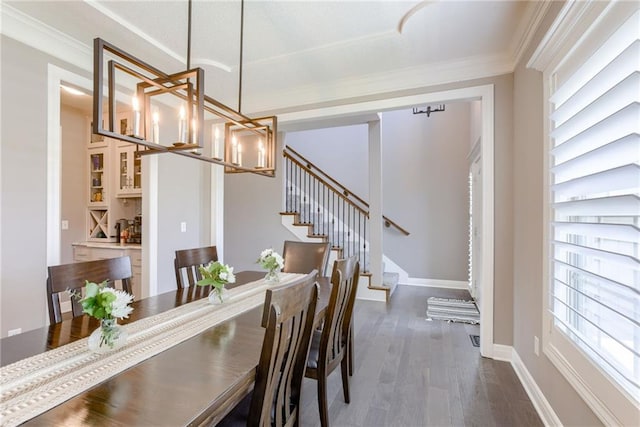 8721 N Mersington Ave, Kansas City, MO 64156 - dining room featuring a chandelier, healthy amount of natural light, dark wood finished floors, stairs, and crown molding