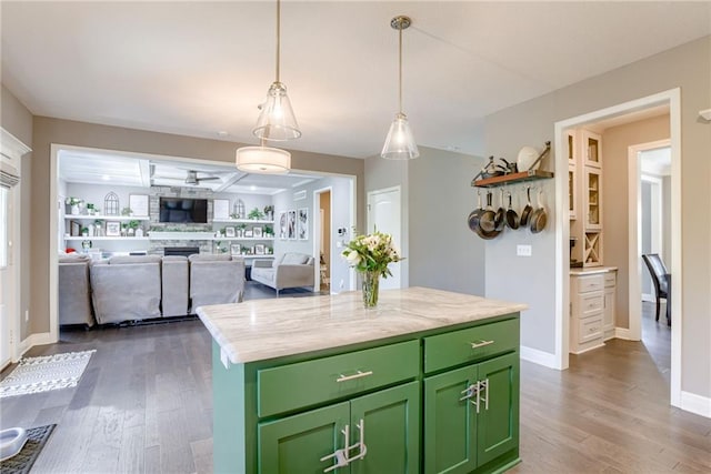 8721 N Mersington Ave, Kansas City, MO 64156 - kitchen featuring green cabinets, dark wood-type flooring, a fireplace, a kitchen island, and decorative light fixtures
