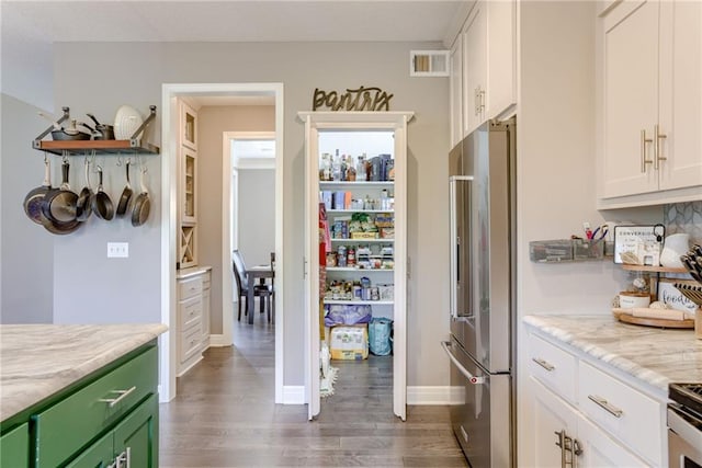 8721 N Mersington Ave, Kansas City, MO 64156 - kitchen with high end fridge, dark wood-style flooring, white cabinetry, green cabinetry, and light stone counters