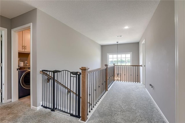 8721 N Mersington Ave, Kansas City, MO 64156 - hallway featuring washer / dryer, carpet, an upstairs landing, and a textured ceiling