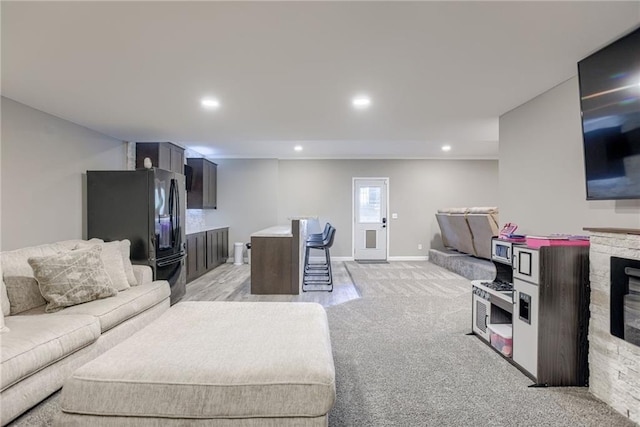8721 N Mersington Ave, Kansas City, MO 64156 - living room with light carpet, recessed lighting, a fireplace, and a wood stove