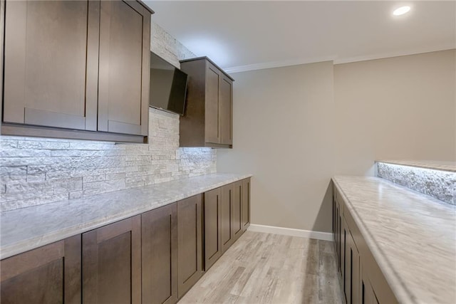 8721 N Mersington Ave, Kansas City, MO 64156 - kitchen with light wood-style flooring, decorative backsplash, dark brown cabinets, light countertops, and recessed lighting