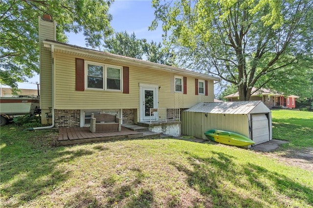 1405 S Vine St, Holden, MO 64040 - back of property featuring a chimney, a lawn, driveway, an outdoor structure, and a wooden deck