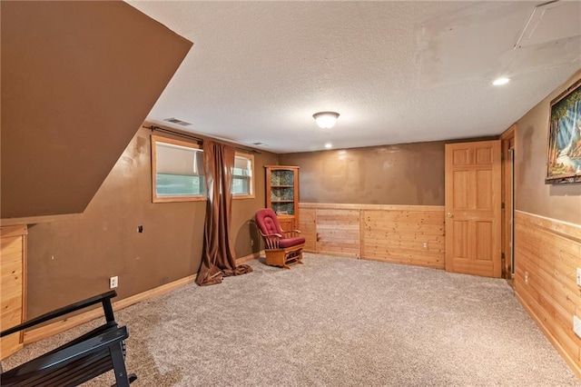 1405 S Vine St, Holden, MO 64040 - living area featuring carpet floors, wood walls, a wainscoted wall, and a textured ceiling
