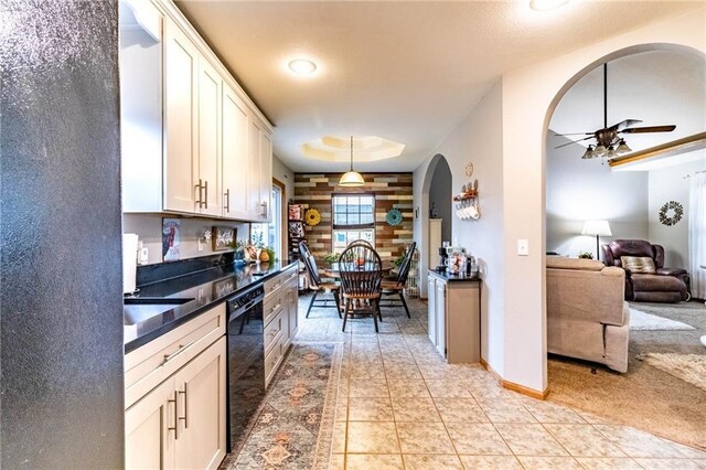 131 NW 171st Rd, Warrensburg, MO 64093 - kitchen featuring arched walkways, dishwasher, ceiling fan, dark countertops, and white cabinetry