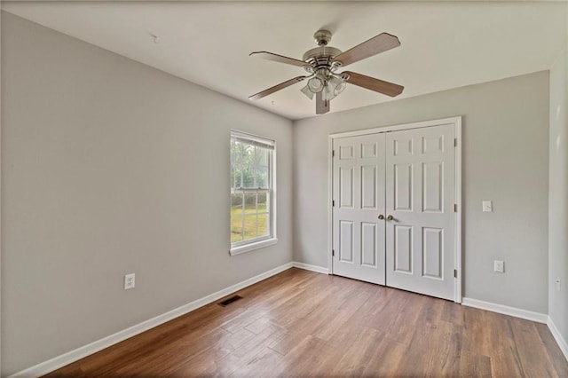 131 NW 171st Rd, Warrensburg, MO 64093 - unfurnished bedroom featuring wood finished floors, a closet, and a ceiling fan