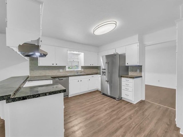 15378 E 45th St S, Independence, MO 64055 - kitchen with appliances with stainless steel finishes, wall chimney range hood, light wood finished floors, white cabinets, and decorative backsplash