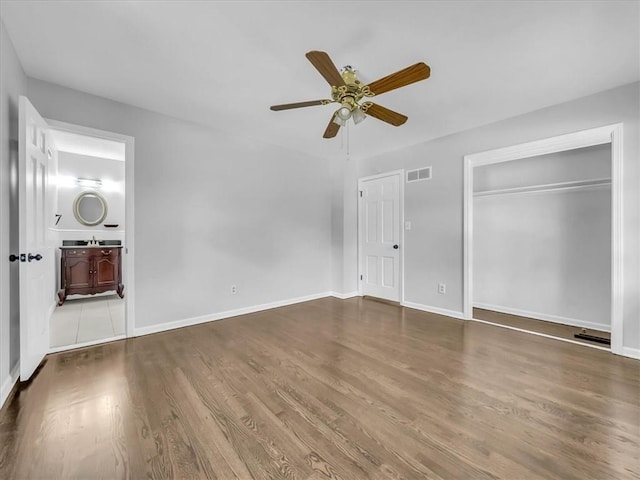 15378 E 45th St S, Independence, MO 64055 - unfurnished bedroom featuring wood finished floors, baseboards, a closet, and a ceiling fan