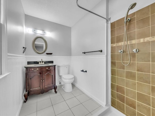 15378 E 45th St S, Independence, MO 64055 - bathroom featuring a wainscoted wall, tile patterned floors, tiled shower, vanity, and toilet