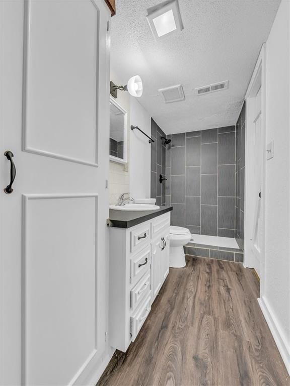 15378 E 45th St S, Independence, MO 64055 - full bathroom with a textured ceiling, a stall shower, toilet, vanity, and wood finished floors