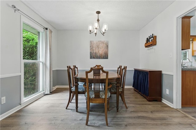 12411 W 100th St, Lenexa, KS 66215 - dining area with a chandelier, wood finished floors, and a textured ceiling