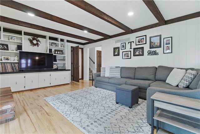 12411 W 100th St, Lenexa, KS 66215 - living area featuring beam ceiling, light wood finished floors, and stairs