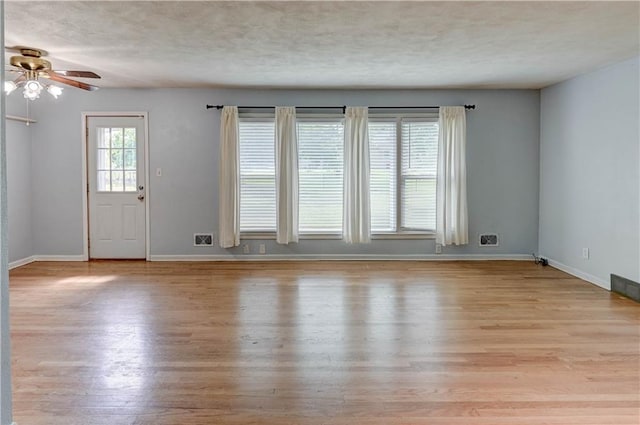 7907 Elm Ave, Raytown, MO 64138 - unfurnished living room with a ceiling fan, light wood-style flooring, and a textured ceiling