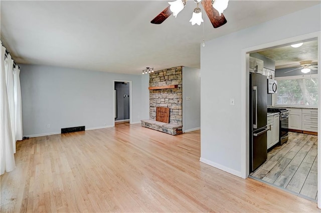 7907 Elm Ave, Raytown, MO 64138 - unfurnished living room featuring a ceiling fan, light wood-style flooring, and a fireplace