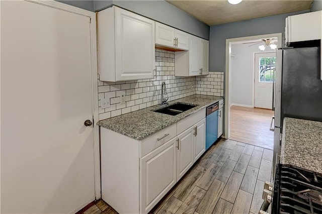 7907 Elm Ave, Raytown, MO 64138 - kitchen featuring appliances with stainless steel finishes, light wood-style floors, white cabinets, backsplash, and light stone countertops