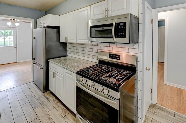 7907 Elm Ave, Raytown, MO 64138 - kitchen featuring appliances with stainless steel finishes, light wood-style flooring, and white cabinets