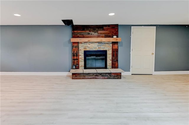 7907 Elm Ave, Raytown, MO 64138 - unfurnished living room with wood finished floors, recessed lighting, and a stone fireplace