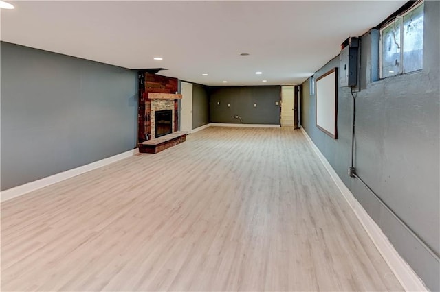 7907 Elm Ave, Raytown, MO 64138 - unfurnished living room with a stone fireplace, light wood-style flooring, and recessed lighting