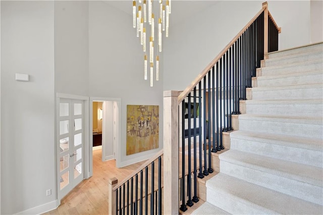 15601 Catalina St, Overland Park, KS 66224 - stairs featuring a towering ceiling, baseboards, wood finished floors, and french doors