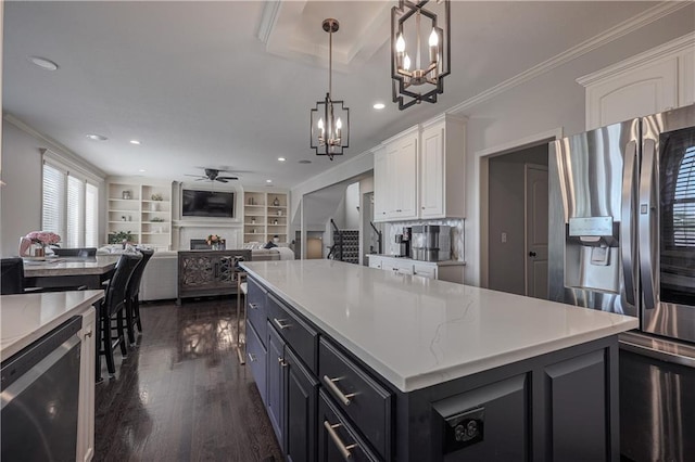 23856 W 124th Ct, Olathe, KS 66061 - kitchen with appliances with stainless steel finishes, a chandelier, a ceiling fan, white cabinetry, and dark wood-style flooring
