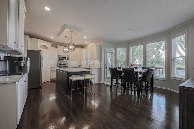 23856 W 124th Ct, Olathe, KS 66061 - kitchen featuring stainless steel appliances, a kitchen island, dark wood-style flooring, crown molding, and recessed lighting