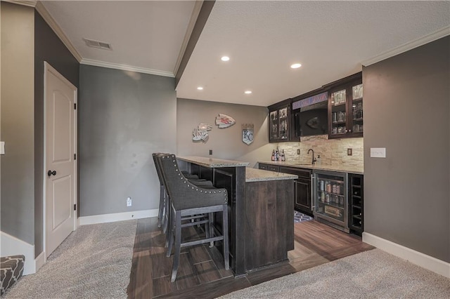 23856 W 124th Ct, Olathe, KS 66061 - indoor wet bar featuring wine cooler, crown molding, recessed lighting, and dark carpet