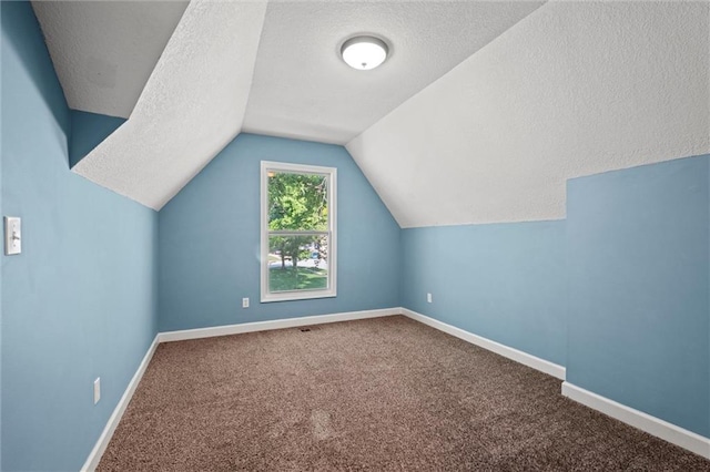 12001 S Hagan St, Olathe, KS 66062 - additional living space with a textured ceiling, carpet, lofted ceiling, and baseboards