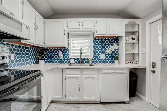 6005 NE 50th St, Kansas City, MO 64119 - kitchen with white appliances, vaulted ceiling, light countertops, white cabinetry, and backsplash