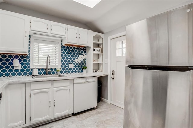 6005 NE 50th St, Kansas City, MO 64119 - kitchen featuring freestanding refrigerator, dishwasher, light countertops, white cabinetry, and vaulted ceiling