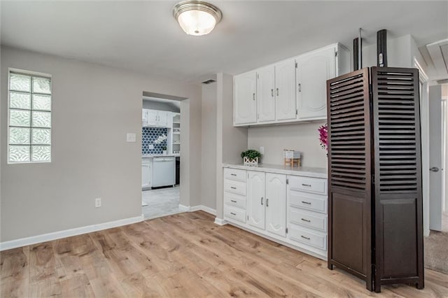 6005 NE 50th St, Kansas City, MO 64119 - kitchen with white dishwasher, white cabinetry, light countertops, and light wood-type flooring