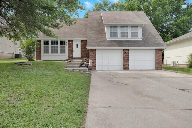 513 Forestglen Ln, Lansing, KS 66043 - tri-level home featuring driveway, brick siding, a front yard, a garage, and roof with shingles