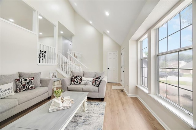 513 Forestglen Ln, Lansing, KS 66043 - living area with high vaulted ceiling, stairway, plenty of natural light, light wood finished floors, and recessed lighting
