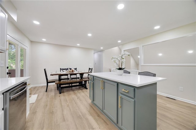 513 Forestglen Ln, Lansing, KS 66043 - kitchen featuring dishwasher, a kitchen island, light countertops, light wood-style floors, and gray cabinetry