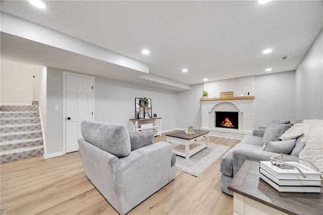 513 Forestglen Ln, Lansing, KS 66043 - living room featuring light wood-style flooring, stairway, recessed lighting, and a fireplace