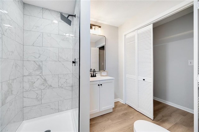 513 Forestglen Ln, Lansing, KS 66043 - bathroom featuring a closet, vanity, a tile shower, and wood finished floors