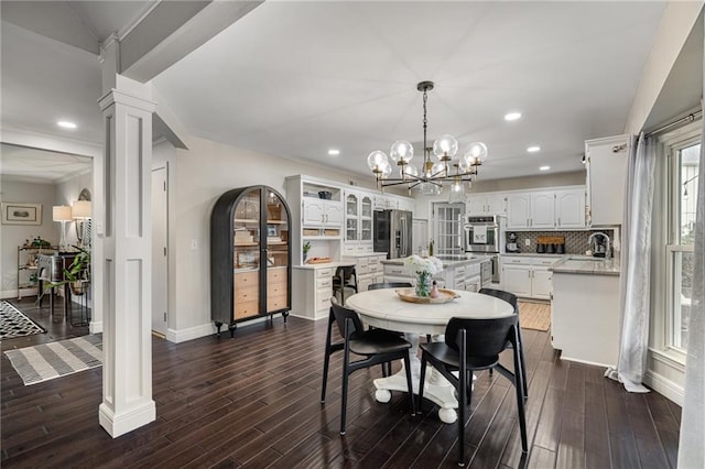 2204 W 123rd Ter, Leawood, KS 66209 - dining space with ornate columns, baseboards, recessed lighting, dark wood-style flooring, and a chandelier