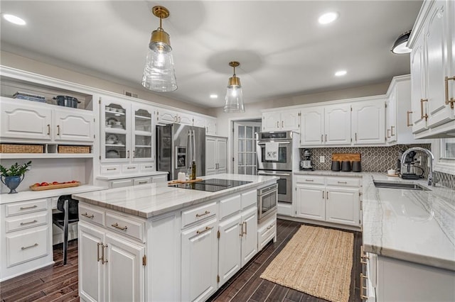 2204 W 123rd Ter, Leawood, KS 66209 - kitchen with stainless steel appliances, a sink, a kitchen island, dark wood-style flooring, and white cabinets