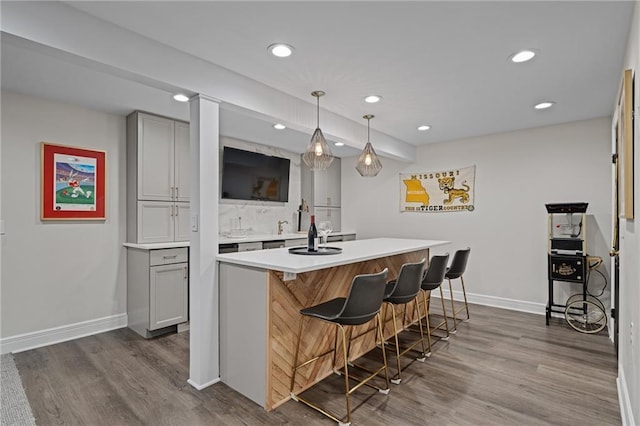 2204 W 123rd Ter, Leawood, KS 66209 - kitchen with dark wood-style floors, recessed lighting, gray cabinetry, baseboards, and a breakfast bar area