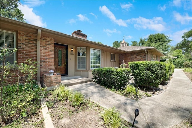 3814 S Outer Belt Rd, Oak Grove, MO 64075 - view of front of house with brick siding, a chimney, and board and batten siding