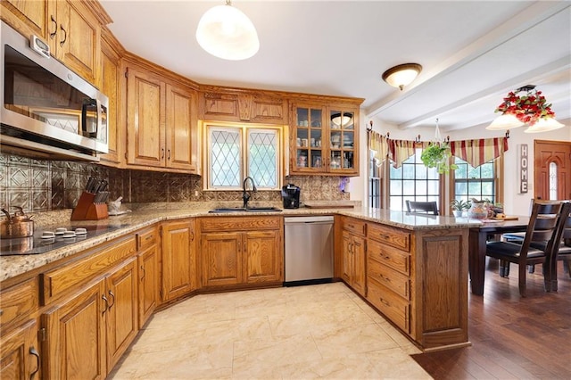 3814 S Outer Belt Rd, Oak Grove, MO 64075 - kitchen with appliances with stainless steel finishes, a peninsula, brown cabinets, tasteful backsplash, and light stone countertops