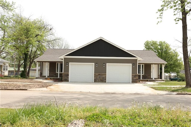 904 N 9th St, Neodesha, KS 66757 - craftsman-style house with covered porch, an attached garage, driveway, and stone siding