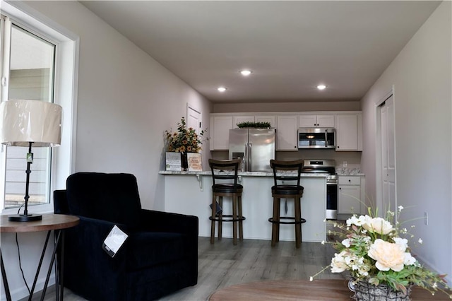 904 N 9th St, Neodesha, KS 66757 - kitchen featuring stainless steel appliances, white cabinets, wood finished floors, recessed lighting, and a peninsula