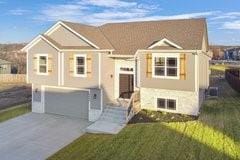 18408 Rock Creek Dr N, Smithville, MO 64089 - split foyer home with concrete driveway, a garage, and a front yard