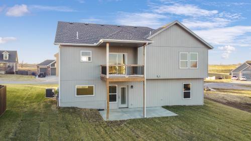 18408 Rock Creek Dr N, Smithville, MO 64089 - rear view of property featuring a patio, a balcony, a lawn, and central AC unit