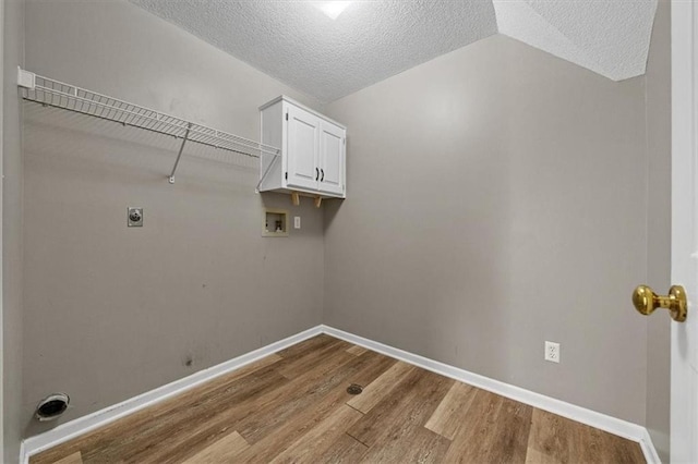 701 NE Hunters Cir, Blue Springs, MO 64014 - washroom with cabinet space, hookup for a washing machine, electric dryer hookup, wood finished floors, and a textured ceiling