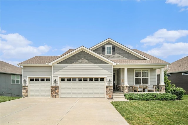24842 W 144th St, Olathe, KS 66061 - craftsman-style home featuring covered porch, stone siding, an attached garage, concrete driveway, and a front lawn