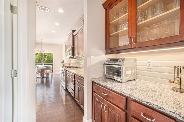 24842 W 144th St, Olathe, KS 66061 - kitchen with stainless steel appliances, dark wood-style floors, glass insert cabinets, light stone countertops, and recessed lighting