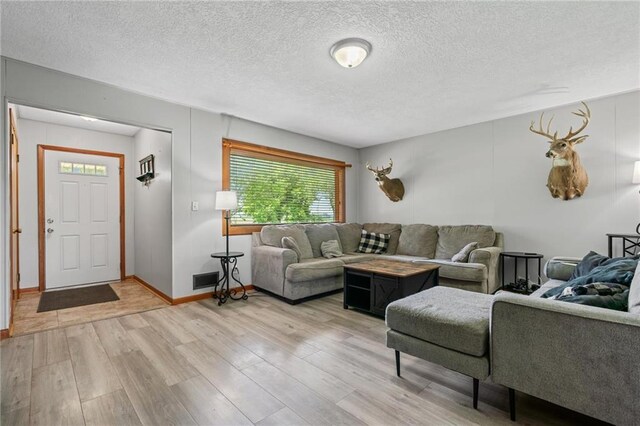 31882 W 180th St, Lawson, MO 64062 - living room with light wood finished floors, a textured ceiling, and baseboards